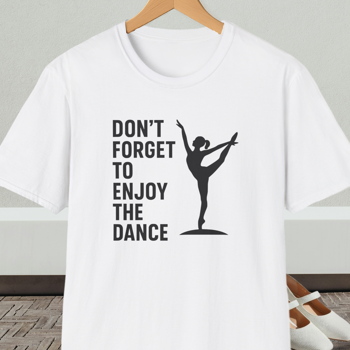 White t-shirt with a black silhouette of a dancer and text 'Don't Forget to Enjoy the Dance'