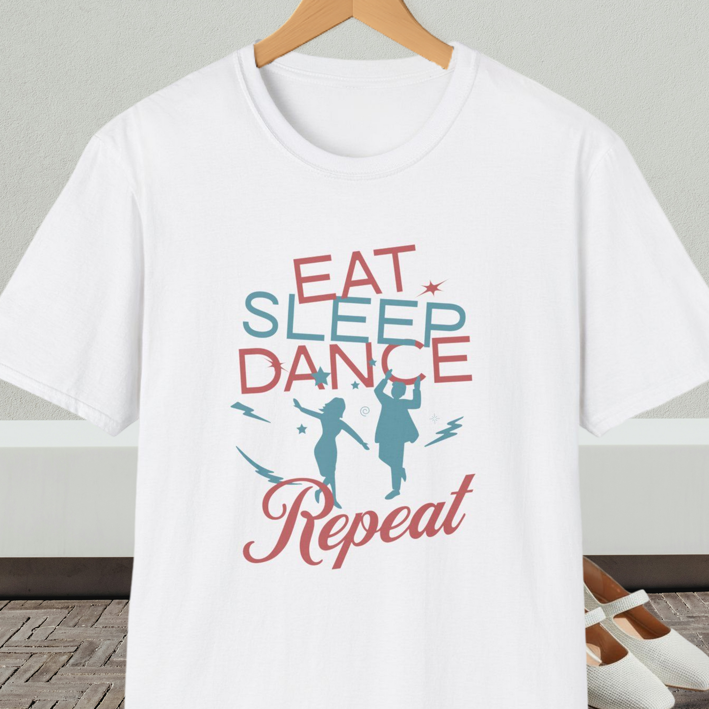 White t-shirt with 'Eat Sleep Dance Repeat' text and graphics on a hanger.