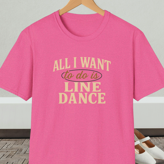 Pink t-shirt with 'All I Want to do is Line Dance' text, on a hanger against a neutral background.