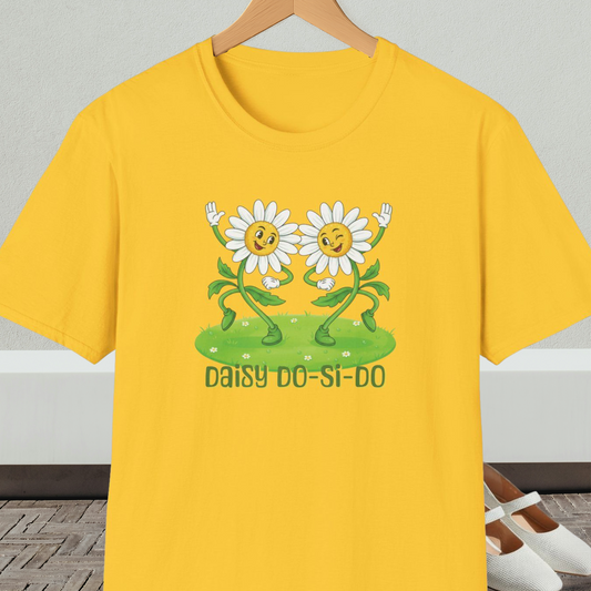 Bright yellow t-shirt with cartoon daisies and text 'Daisy Do-Si-Do' on a wooden hanger against a white wall.