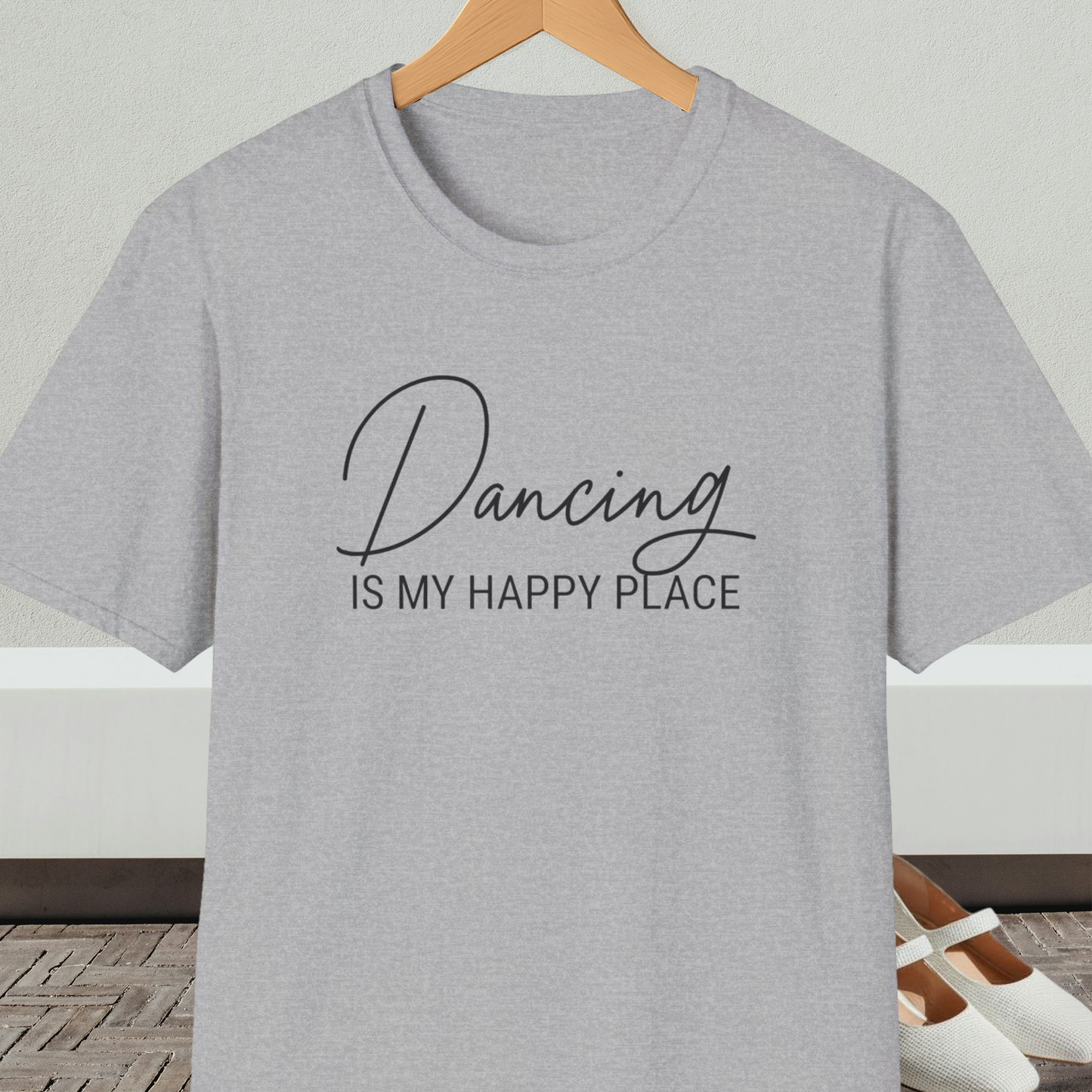 Light gray t-shirt with 'Dancing IS MY HAPPY PLACE' text on a hanger against a neutral background.