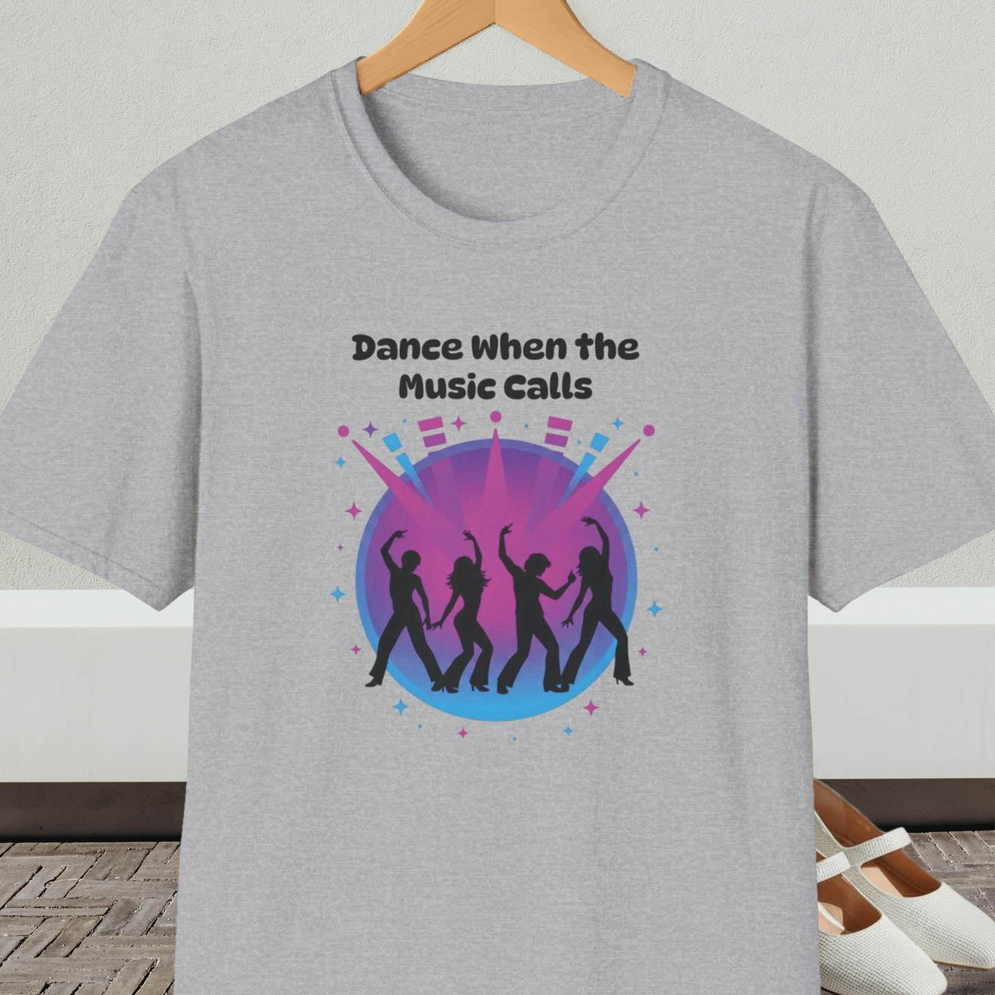 Gray t-shirt with 'Dance When the Music Calls' dance club design, on a hanger against a neutral background.