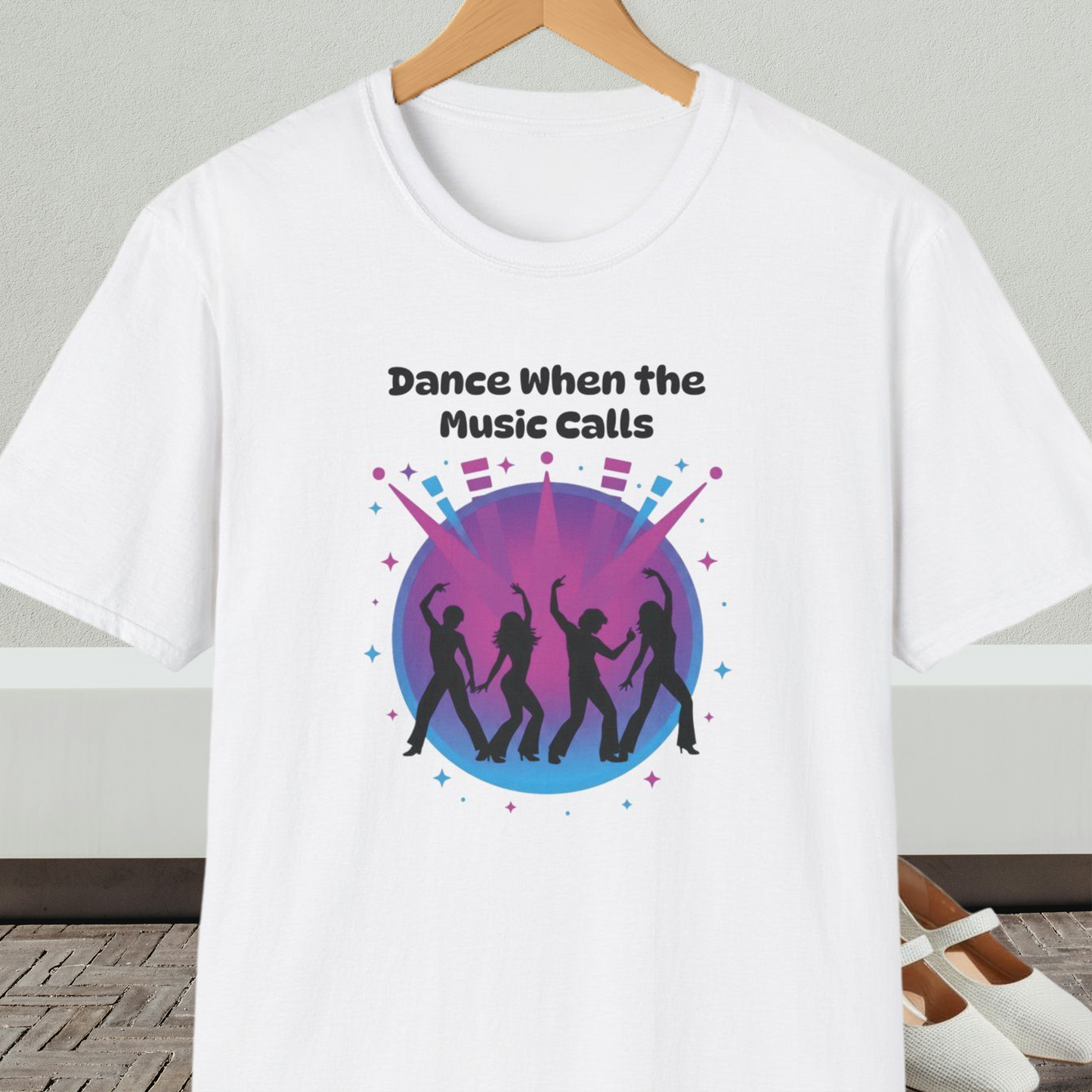 White t-shirt with 'Dance When the Music Calls' dance club design, on a hanger against a neutral background.