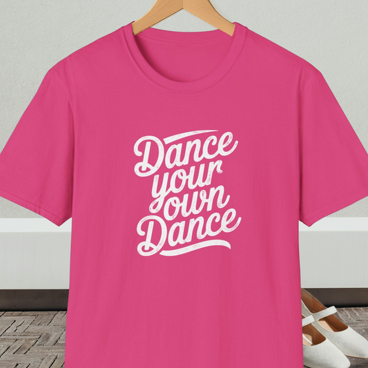 Bright pink t-shirt with 'Dance your own Dance' text, on a hanger against a neutral background