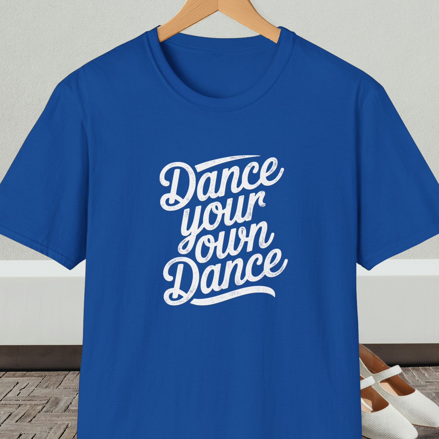 Royal blue t-shirt with 'Dance your own Dance' text, on a hanger against a neutral background