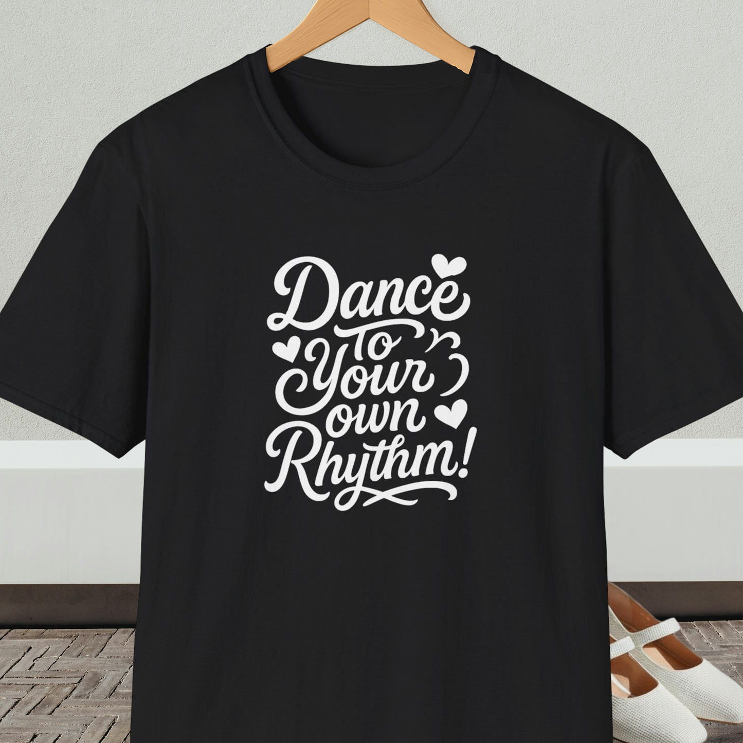 Black t-shirt with 'Dance to Your Own Rhythm!' text, on a hanger against a neutral background.