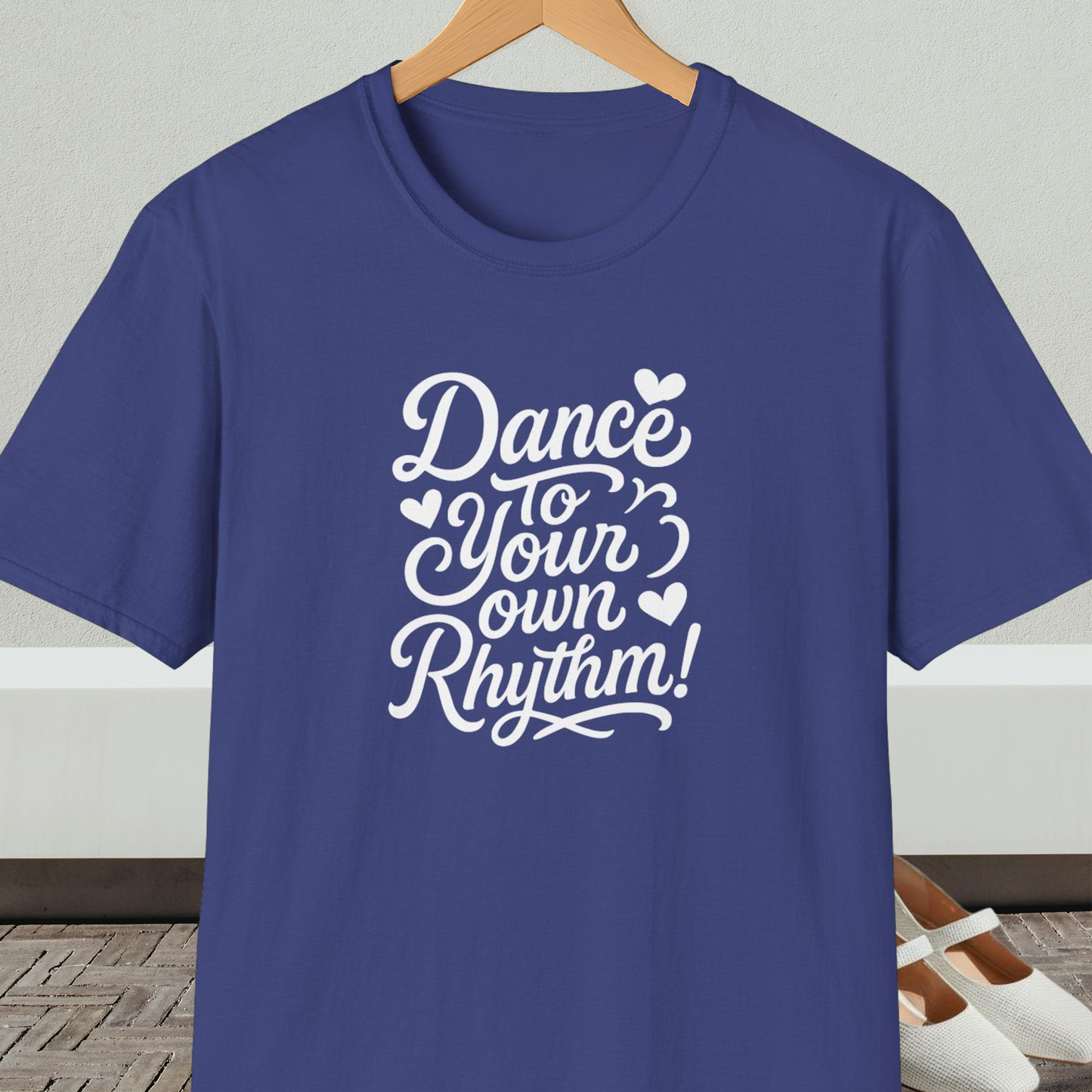 Blue t-shirt with 'Dance to Your Own Rhythm!' text, on a hanger against a neutral background.