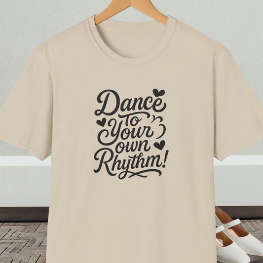 Beige t-shirt with 'Dance to Your Own Rhythm!' text, on a hanger against a neutral background.