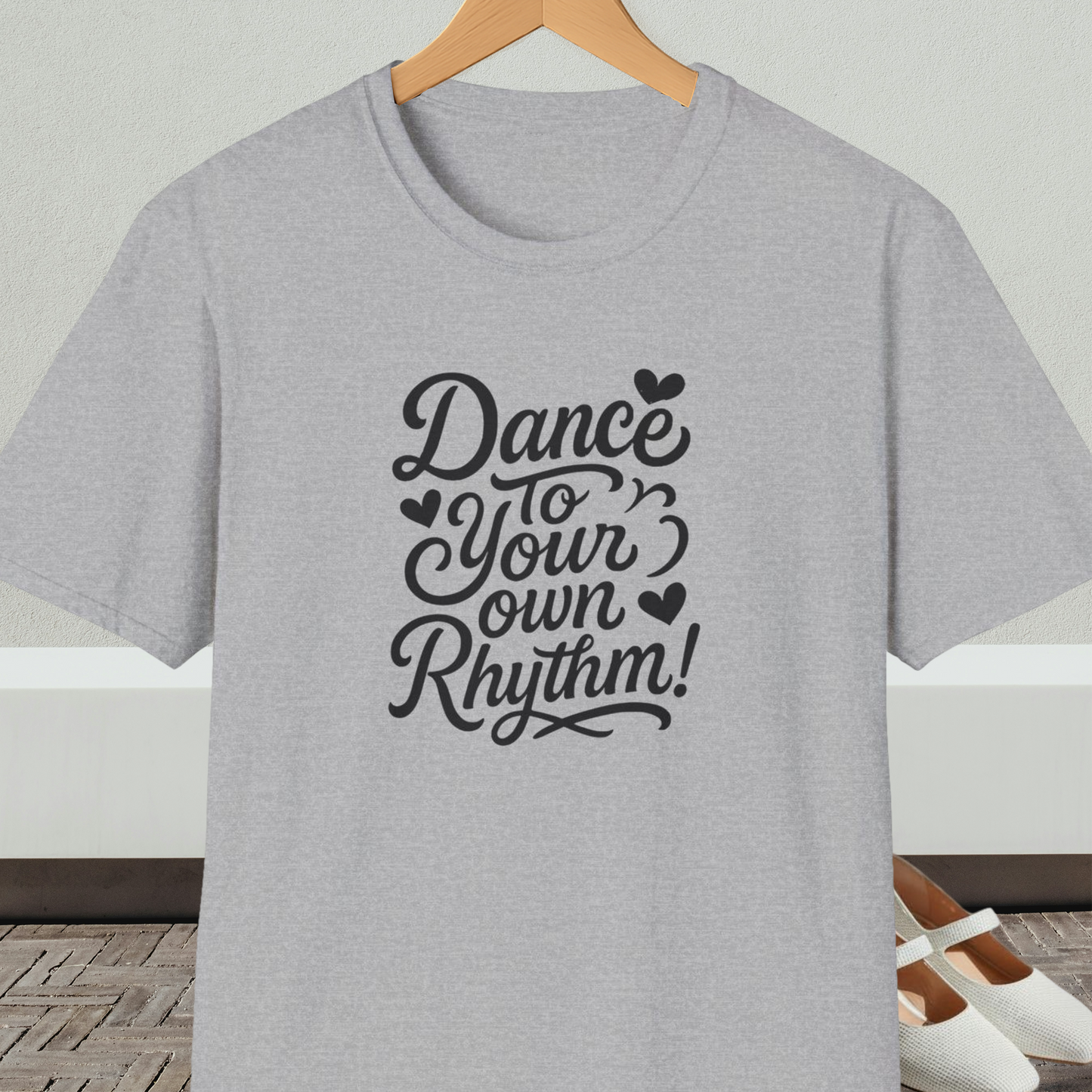 Gray t-shirt with 'Dance to Your Own Rhythm!' text, on a hanger against a neutral background.