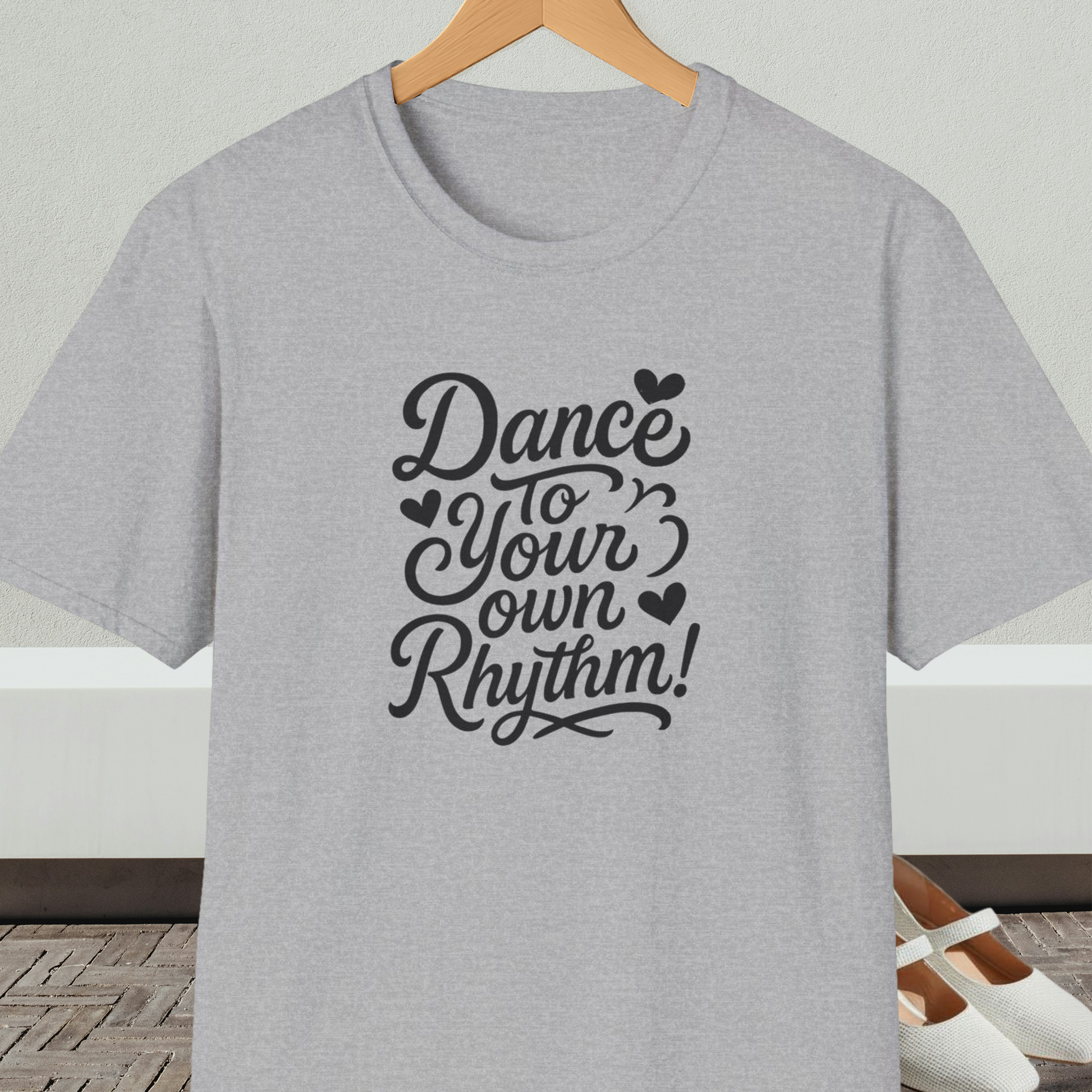 Gray t-shirt with 'Dance to Your Own Rhythm!' text, on a hanger against a neutral background.
