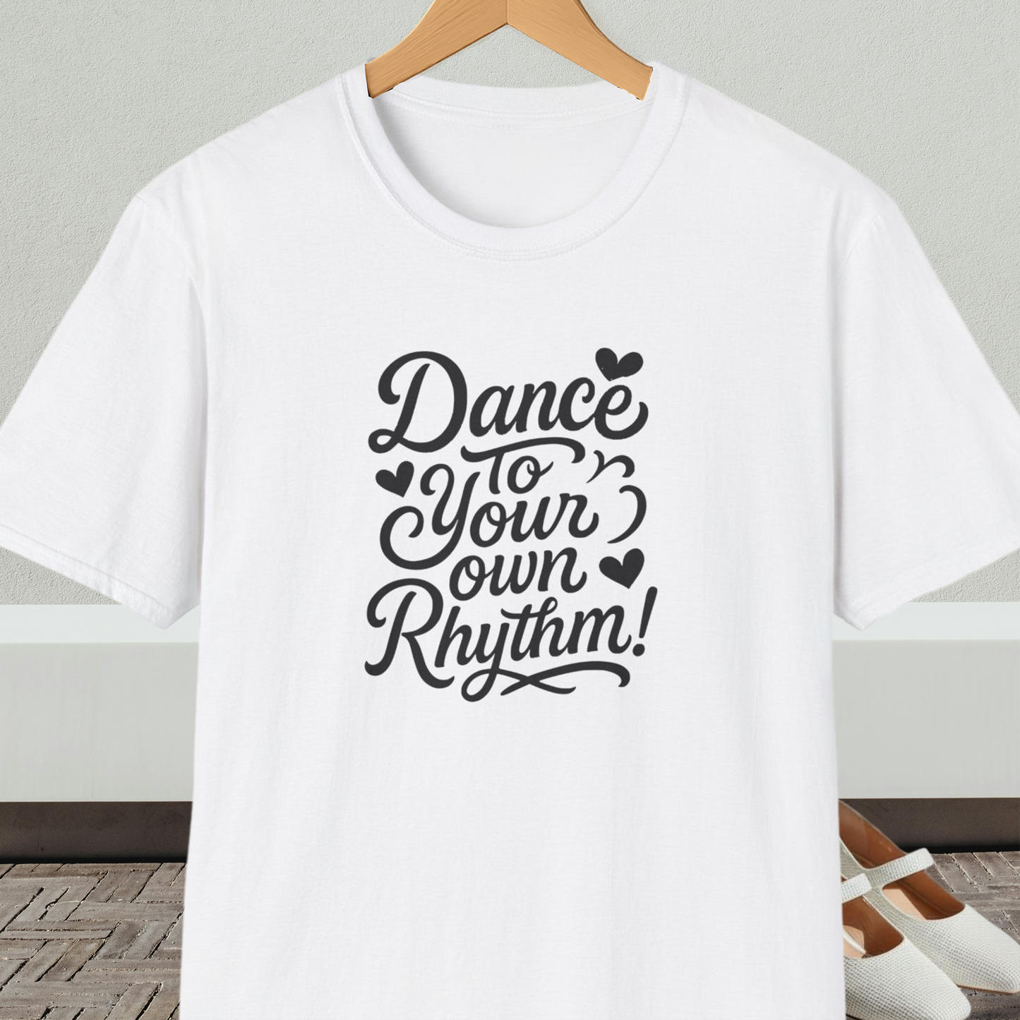 White t-shirt with 'Dance to Your Own Rhythm!' text, on a hanger against a neutral background.
