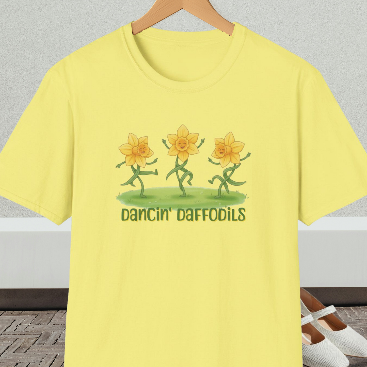 Yellow t-shirt with 'Dancin' Daffodils' design, on a hanger against a neutral background.