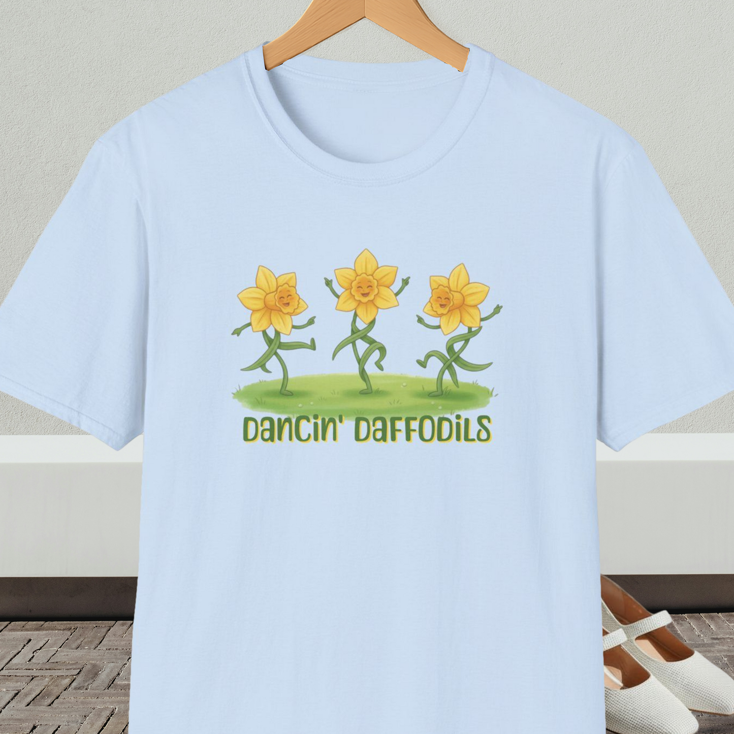 Light blue t-shirt with 'Dancin' Daffodils' design, on a hanger against a neutral background.