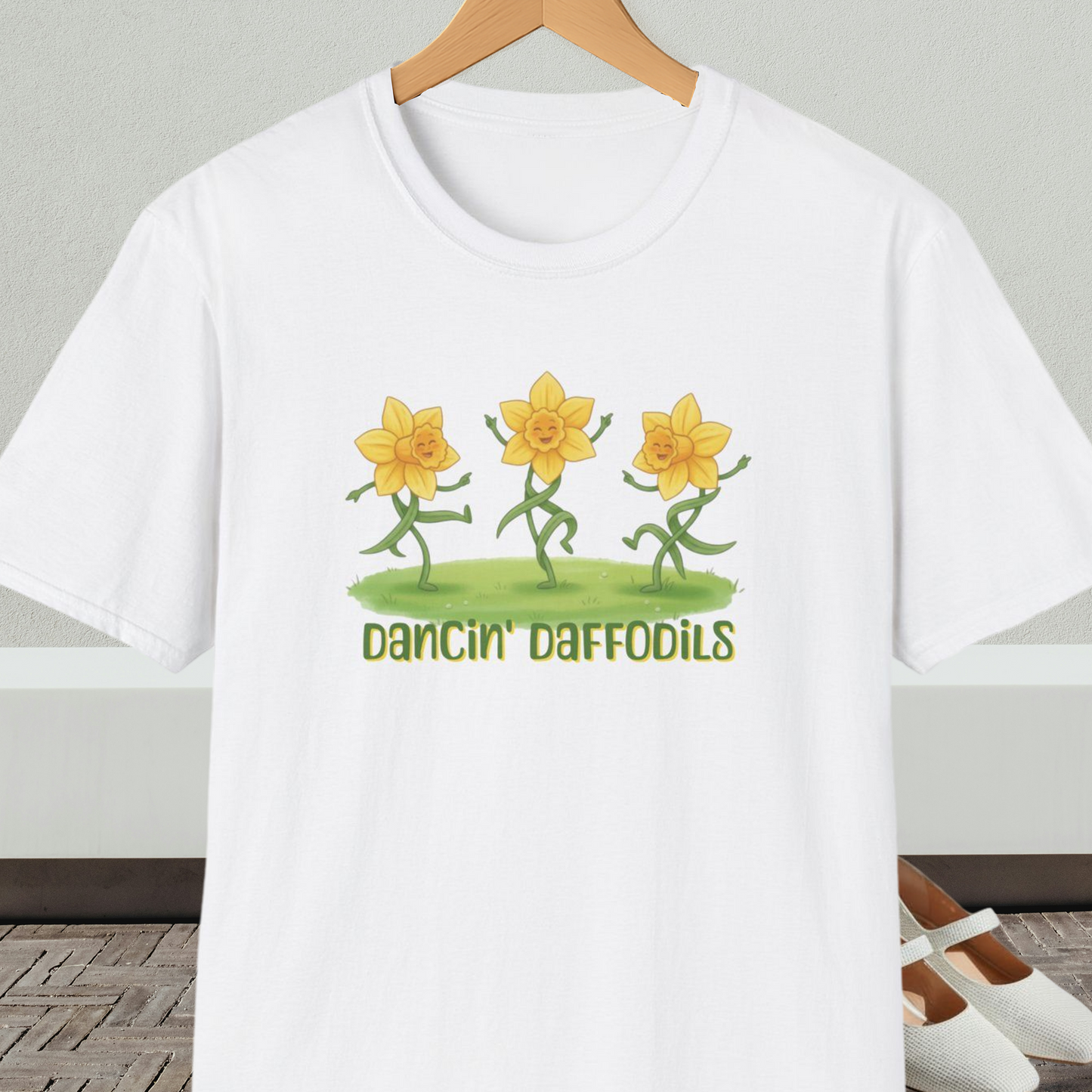 White t-shirt with 'Dancin' Daffodils' design, on a hanger against a neutral background.