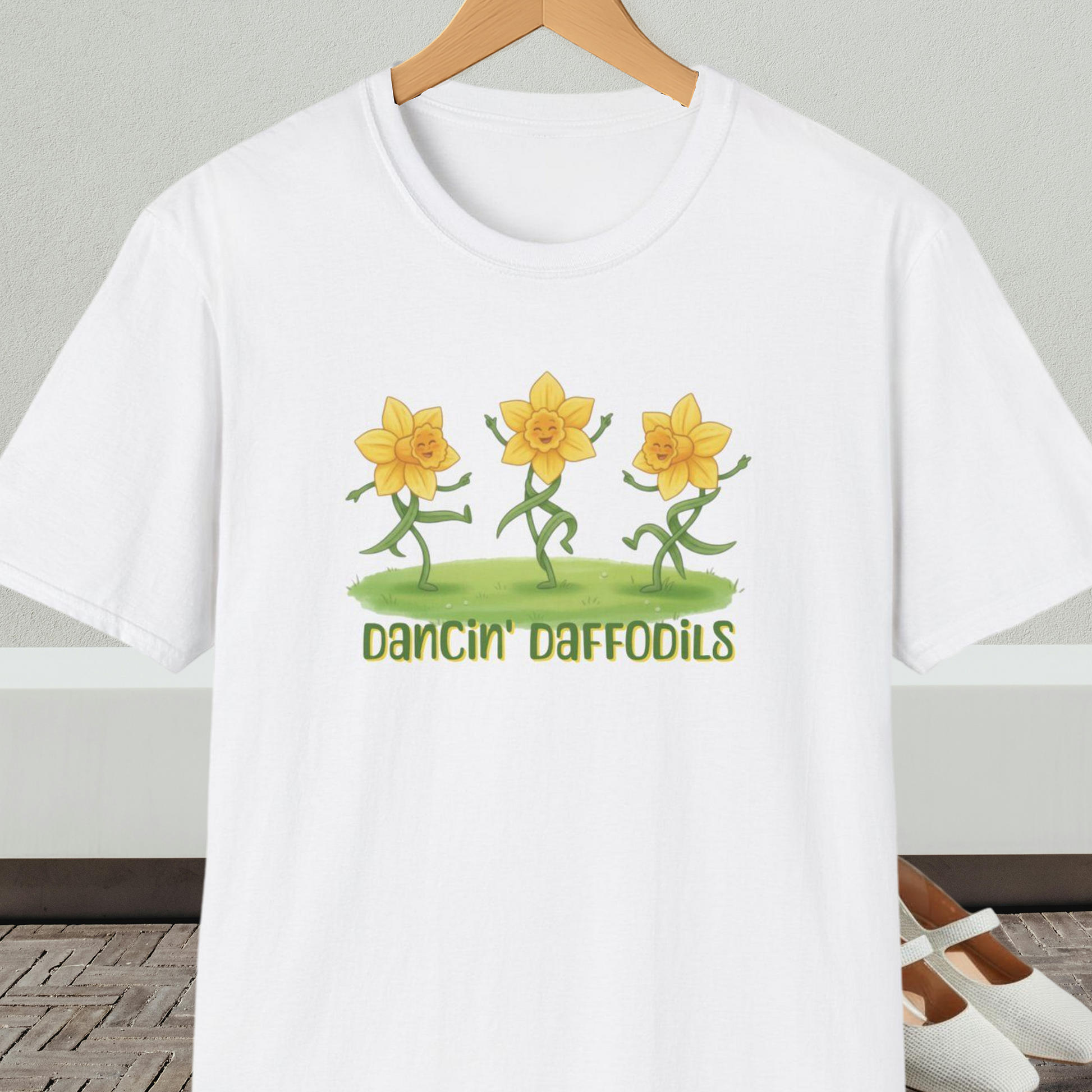 White t-shirt with 'Dancin' Daffodils' design, on a hanger against a neutral background.