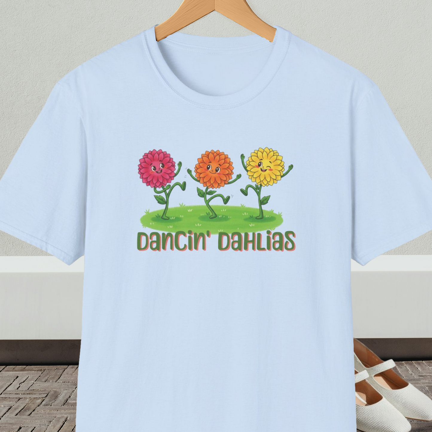 Light blue t-shirt with 'Dancin' Dahlias' design, on a hanger against a neutral background.