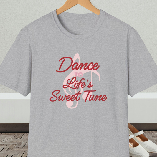 Gray t-shirt with 'Dance to Life's Sweet Tune' text and pink musical note design, on a hanger against a neutral background.