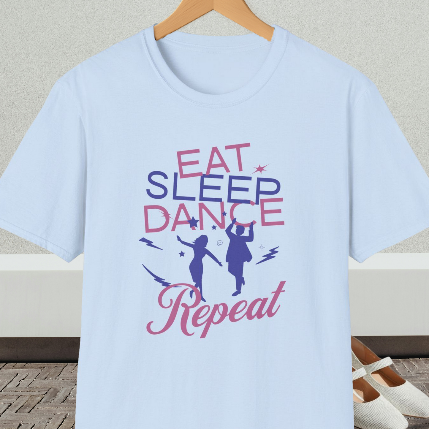 Light blue t-shirt with 'Eat Sleep Dance Repeat' text and graphics on a hanger.