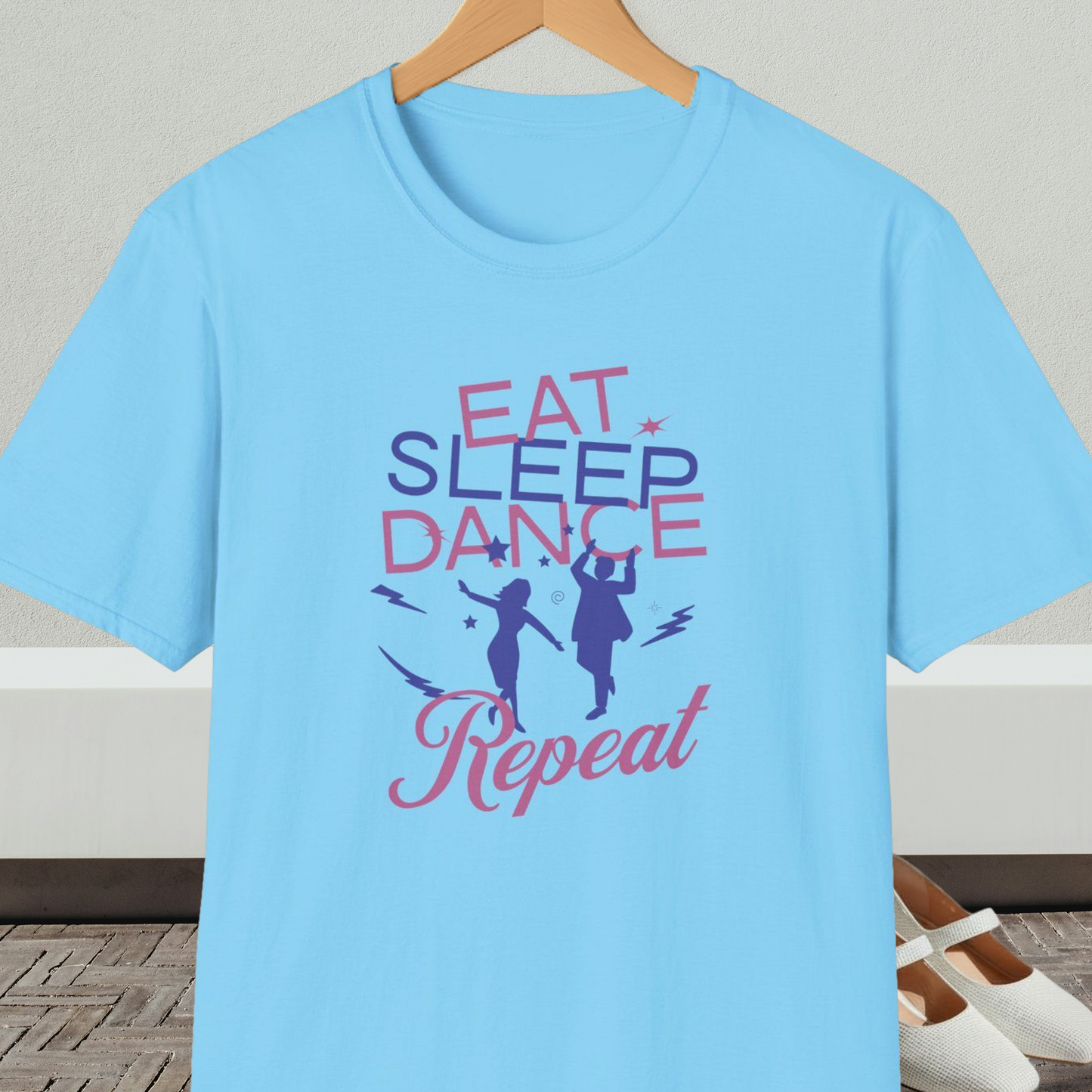 Sky blue t-shirt with 'Eat Sleep Dance Repeat' text and graphics on a hanger.