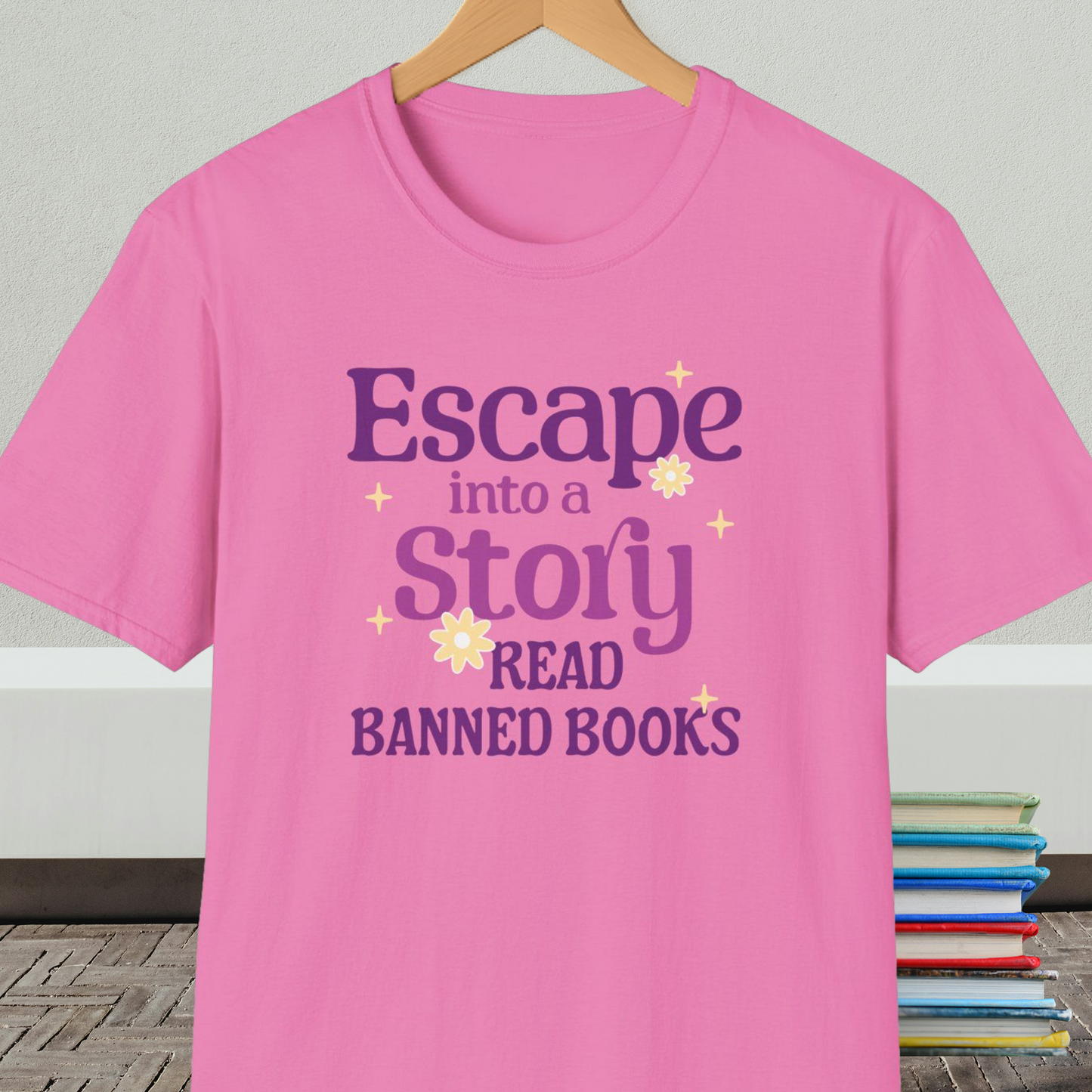 Pink t-shirt on a hanger, with text 'Escape into a Story, Read Banned Books'