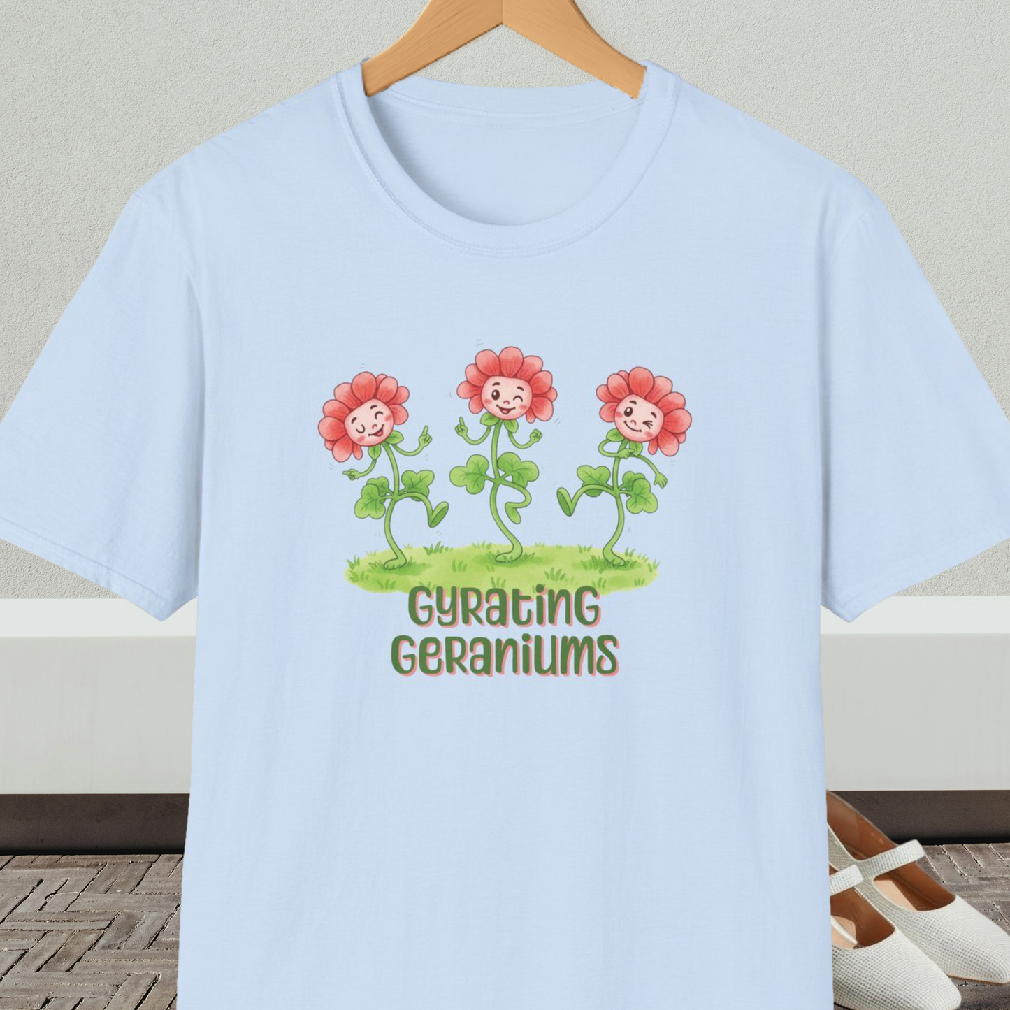 Light blue T-shirt with dancing cartoon flowers and text 'Gyrating Geraniums'