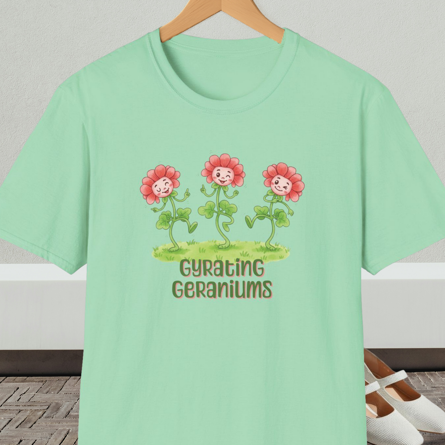 Mint green T-shirt with dancing cartoon flowers and text 'Gyrating Geraniums'