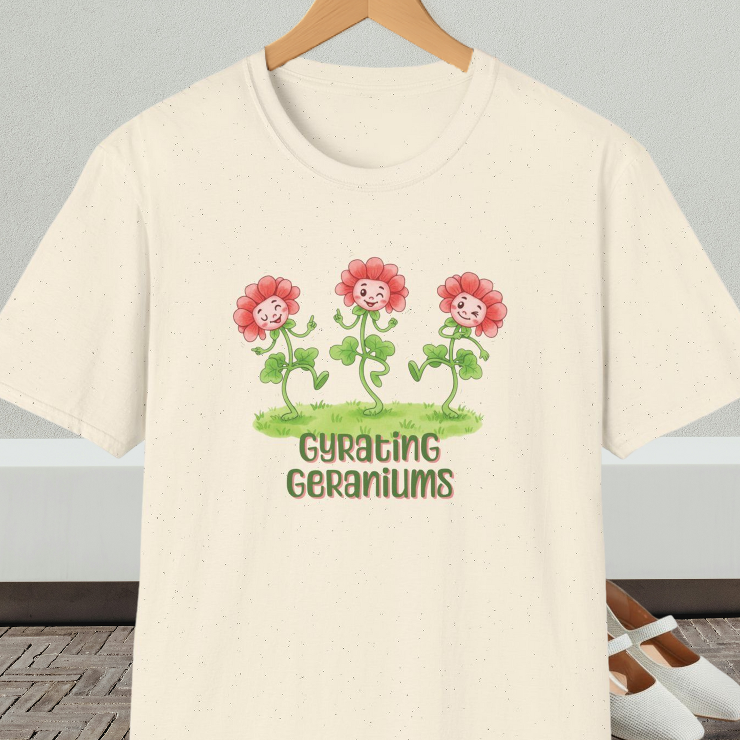 Natural beige T-shirt with dancing cartoon flowers and text 'Gyrating Geraniums'