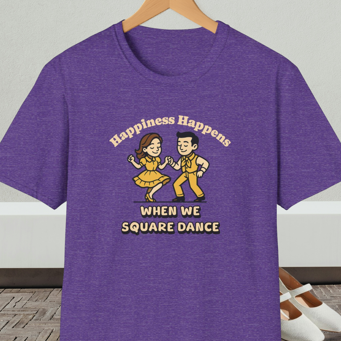 Purple t-shirt with a graphic of two people square dancing and text 'Happiness Happens When We Square Dance'