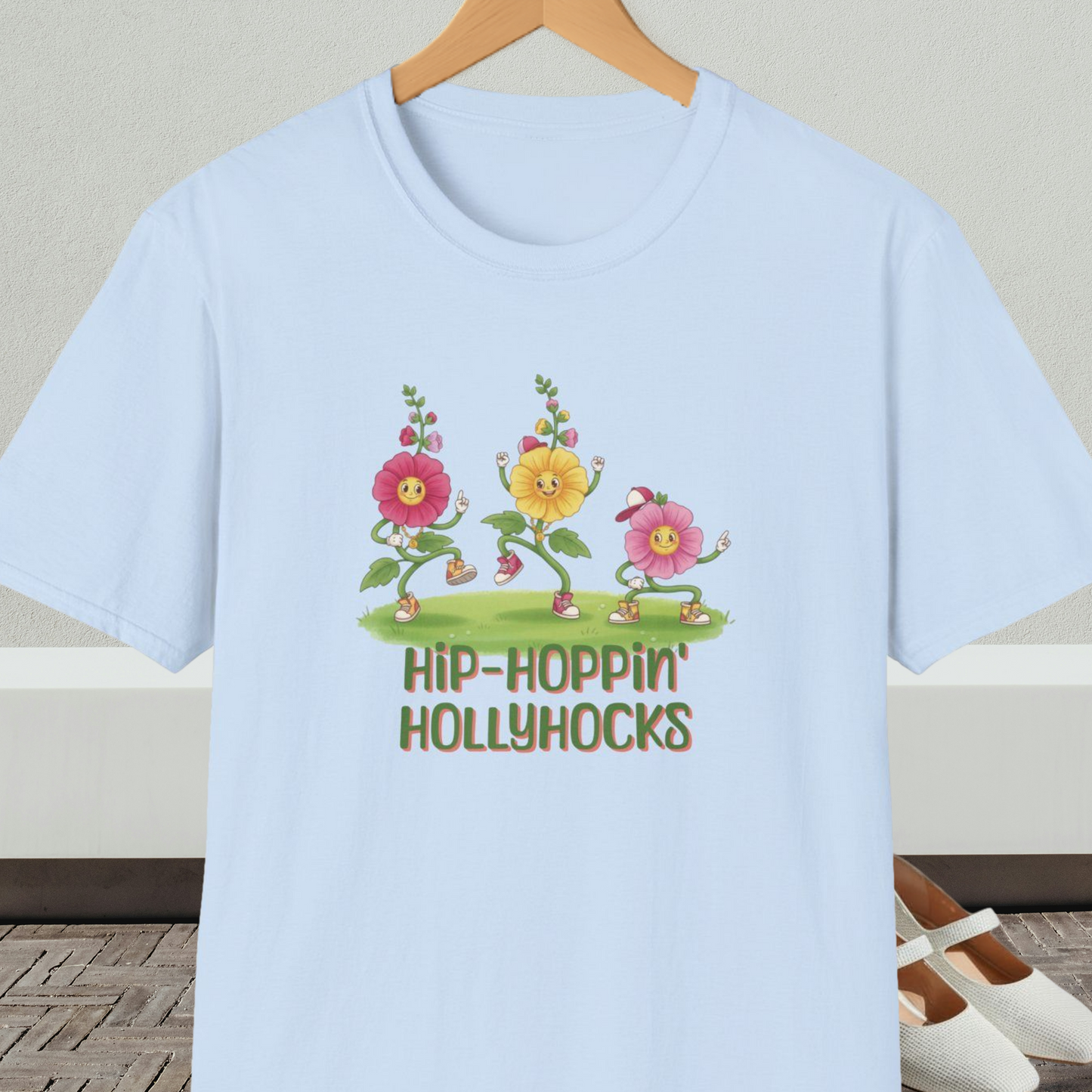 Light blue t-shirt with cartoon dancing floral design and 'Hip-Hoppin Hollyhocks' text 