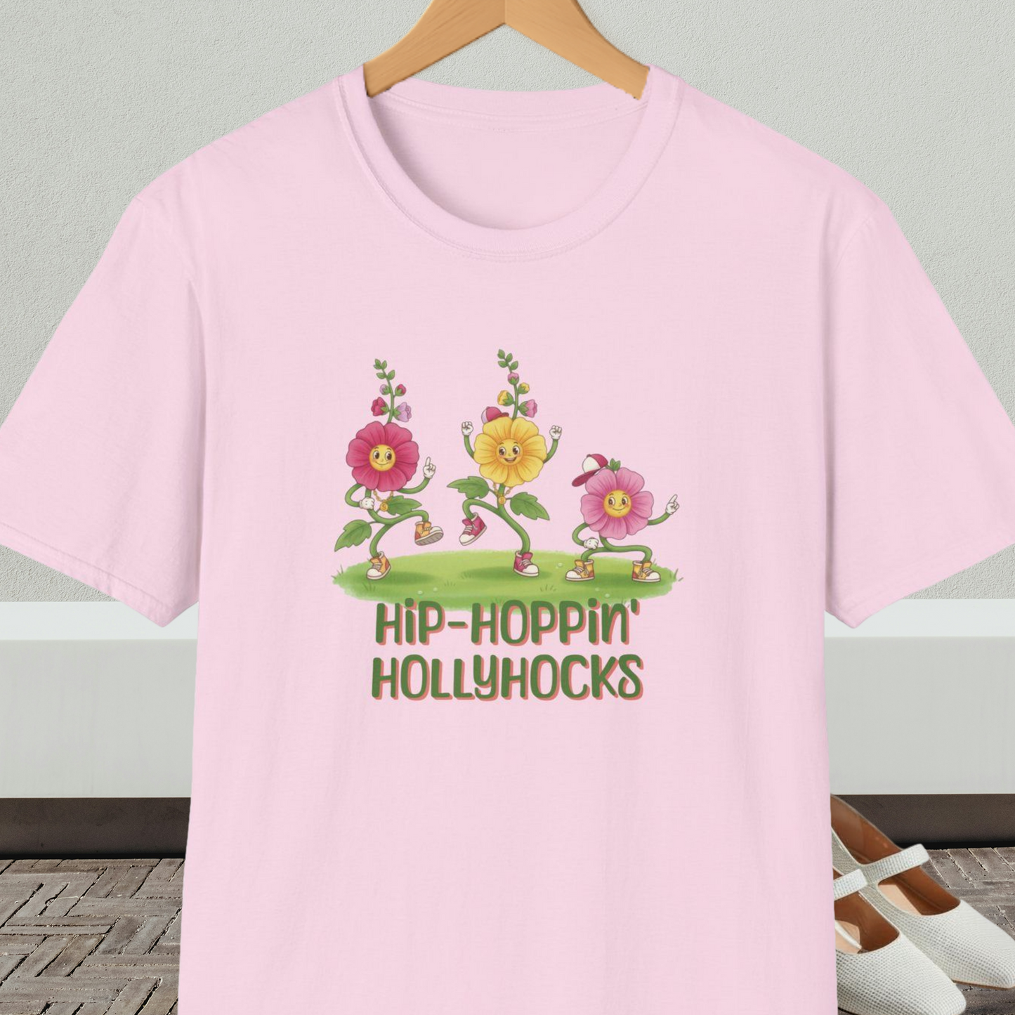 Light pink t-shirt with cartoon dancing floral design and 'Hip-Hoppin Hollyhocks' text 