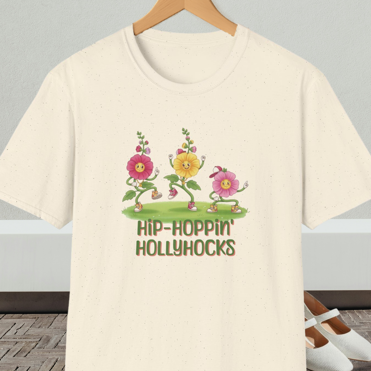 Natural beige t-shirt with cartoon dancing floral design and 'Hip-Hoppin Hollyhocks' text 