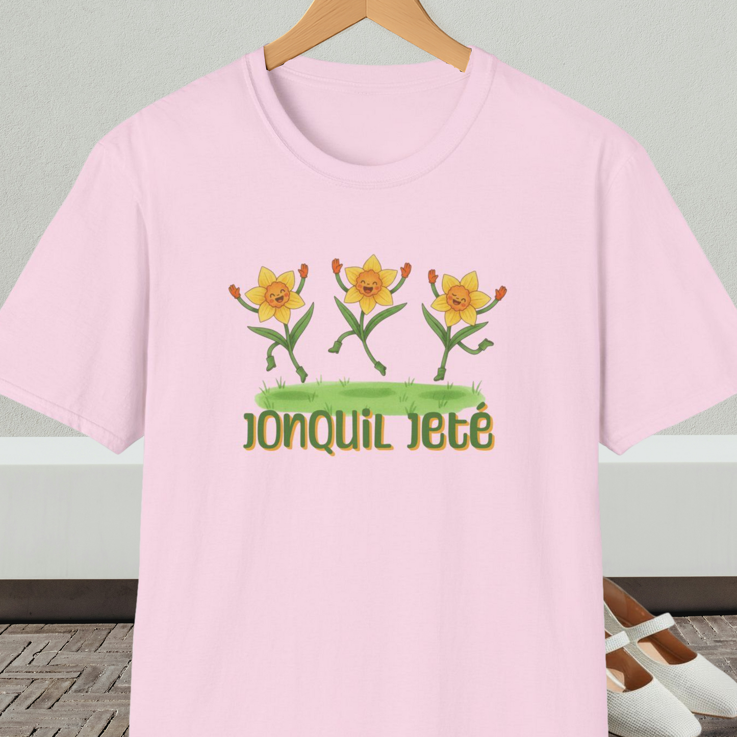 Light pink t-shirt with cartoon dancing jonquils and 'Jonquil Jeté' text.