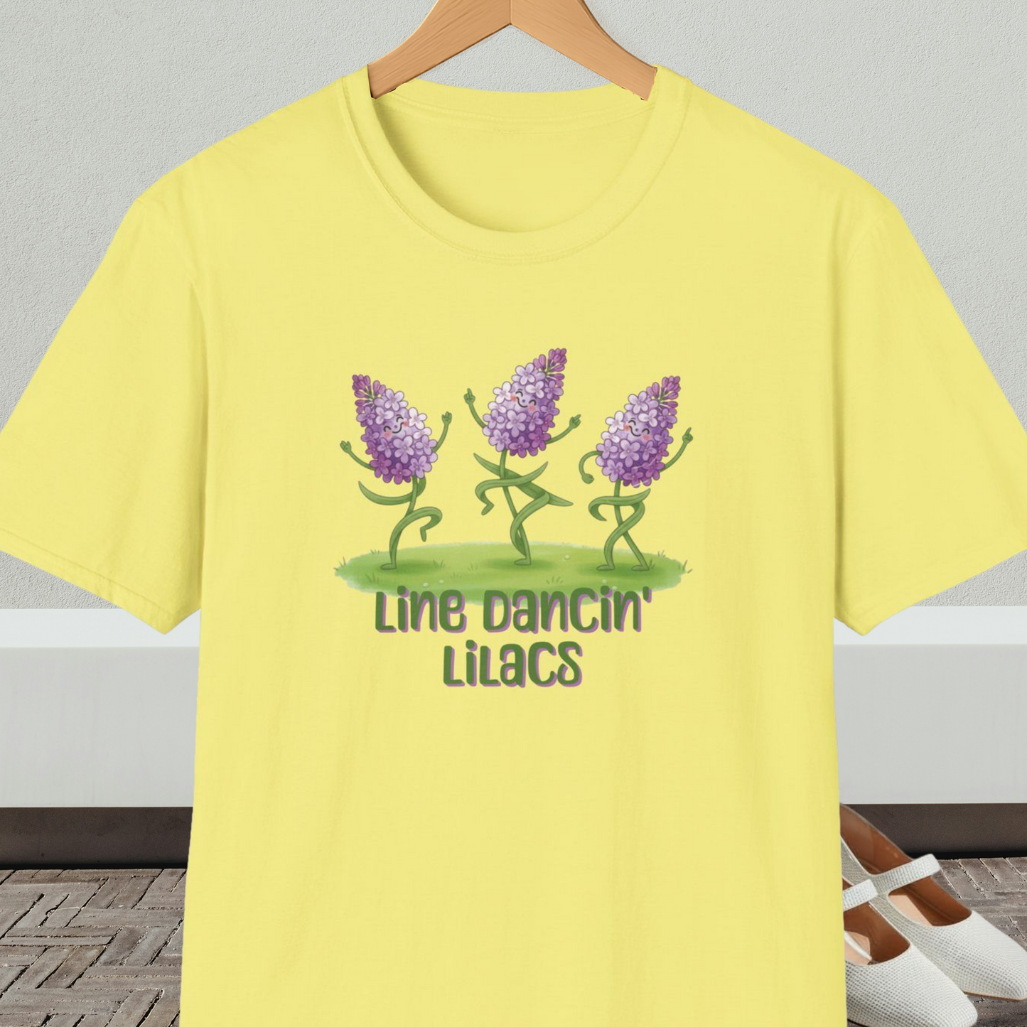 Yellow t-shirt with text 'Line Dancin' Lilacs' and dancing flowers cartoon design.