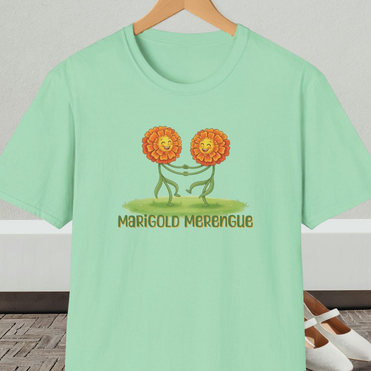 Mint green t-shirt with 'Marigold Merengue' cartoon dancing flowers design