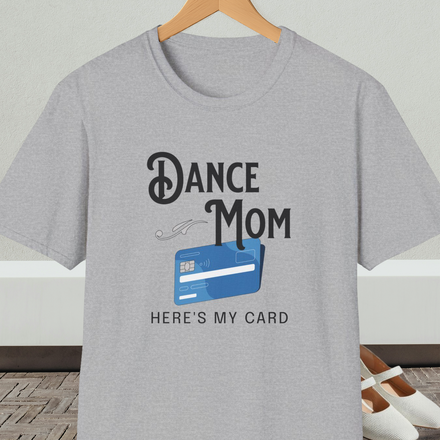 Gray t-shirt with 'Dance Mom, Here's My Card' text and credit card graphic, on a hanger with a neutral background.