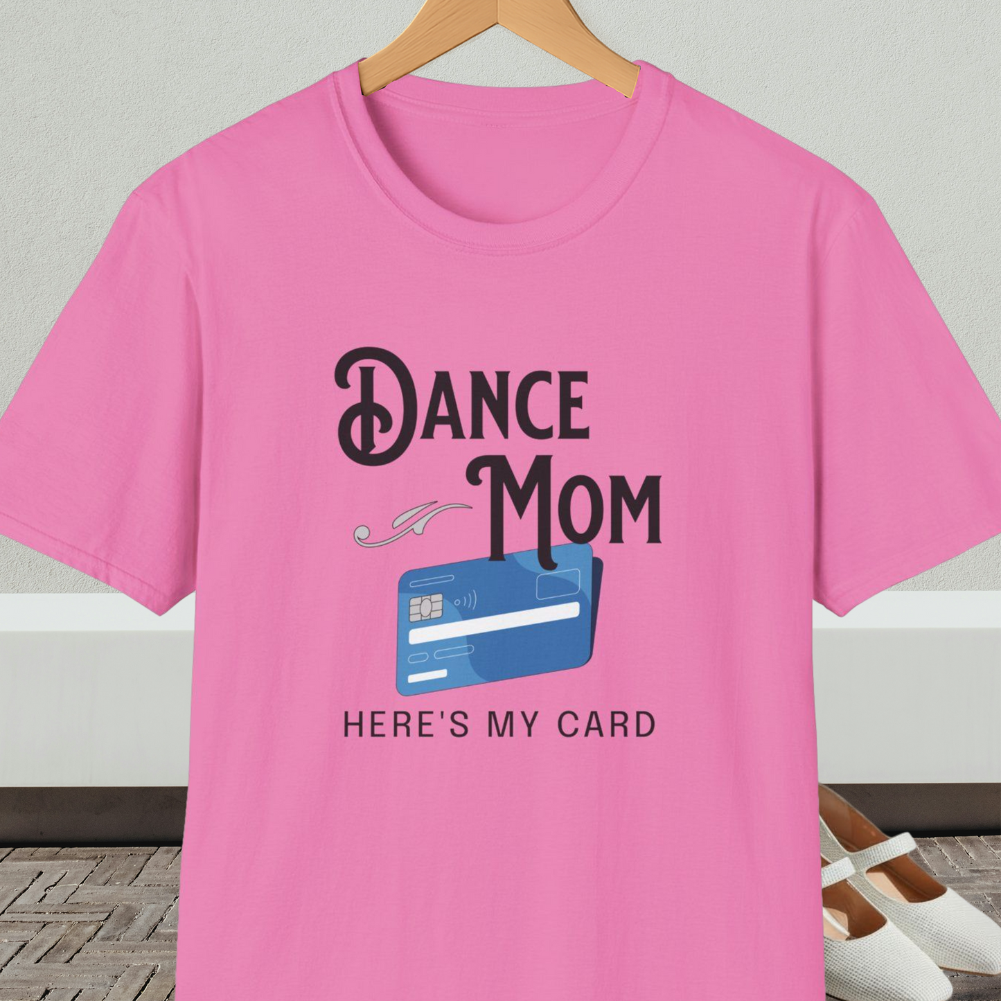 Pink t-shirt with 'Dance Mom, Here's My Card' text and credit card graphic, on a hanger with a neutral background.