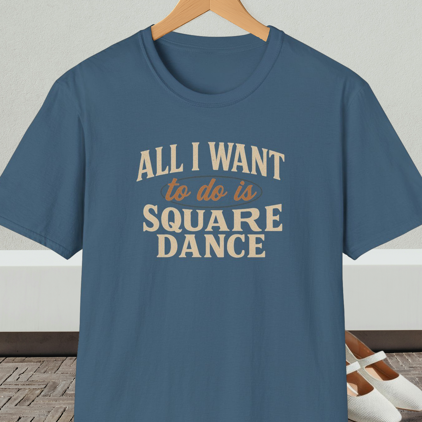 Steel blue t-shirt with text 'All I Want to do is Square Dance' on a hanger against a neutral background.