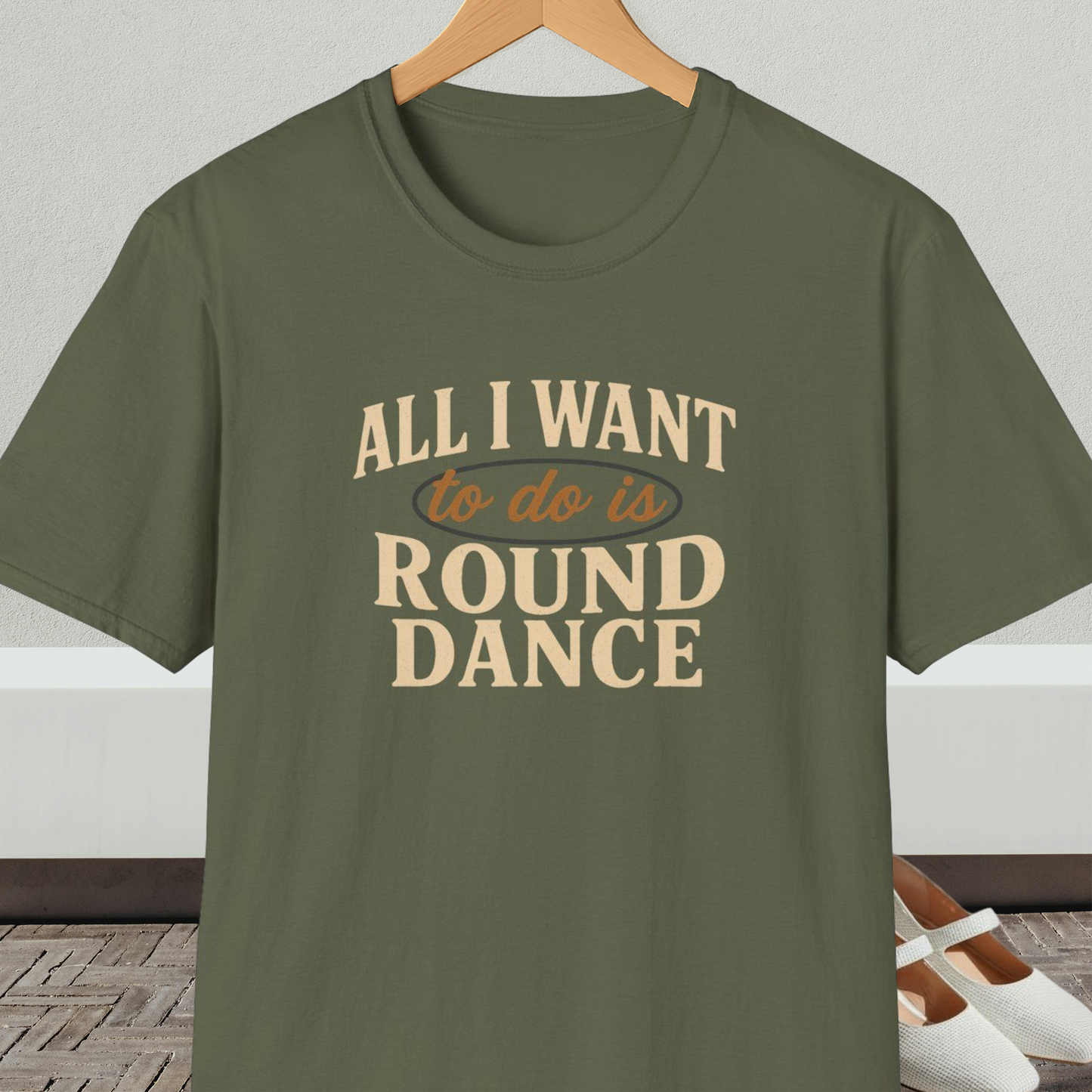Military green t-shirt with text 'All I Want to do is Round Dance' on a hanger against a neutral background.